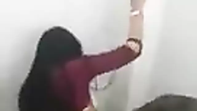 A brunette woman has sex with a Tajik man in the restroom